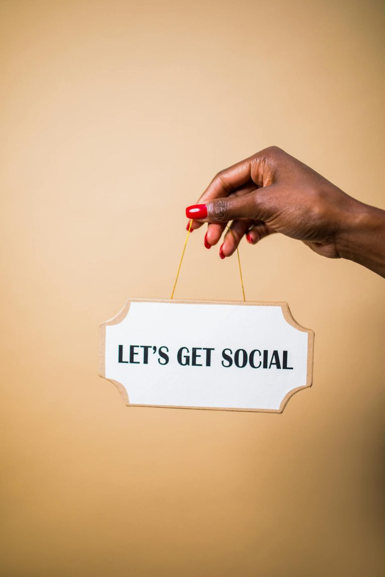 Effective Blog Promotion: Strategies to Increase Your Reach 6 A hand holding a "Let's Get Social" sign, ideal for marketing and social media themes.
